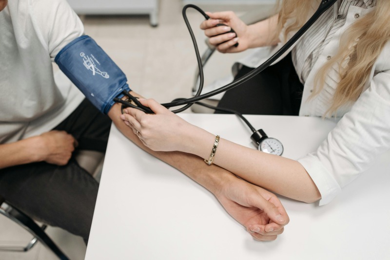 medical assistant helping doctor to check blood pressure
